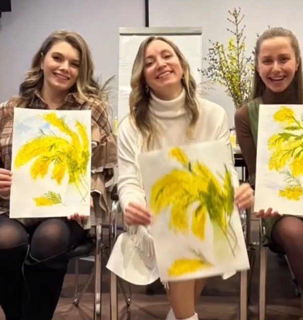 Corporate watercolor workshop participants with their finished works